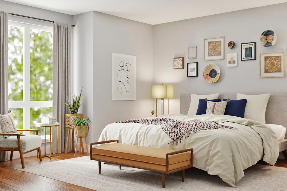 Dormitorio con cama, banco de cuero y cuadros en la pared